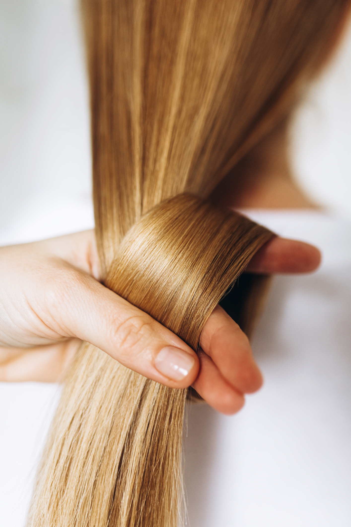 2026-tavaszi-hajszinek-trendek | Marie Claire hosszú, egészséges, szőke hajat fog össze egy női kéz