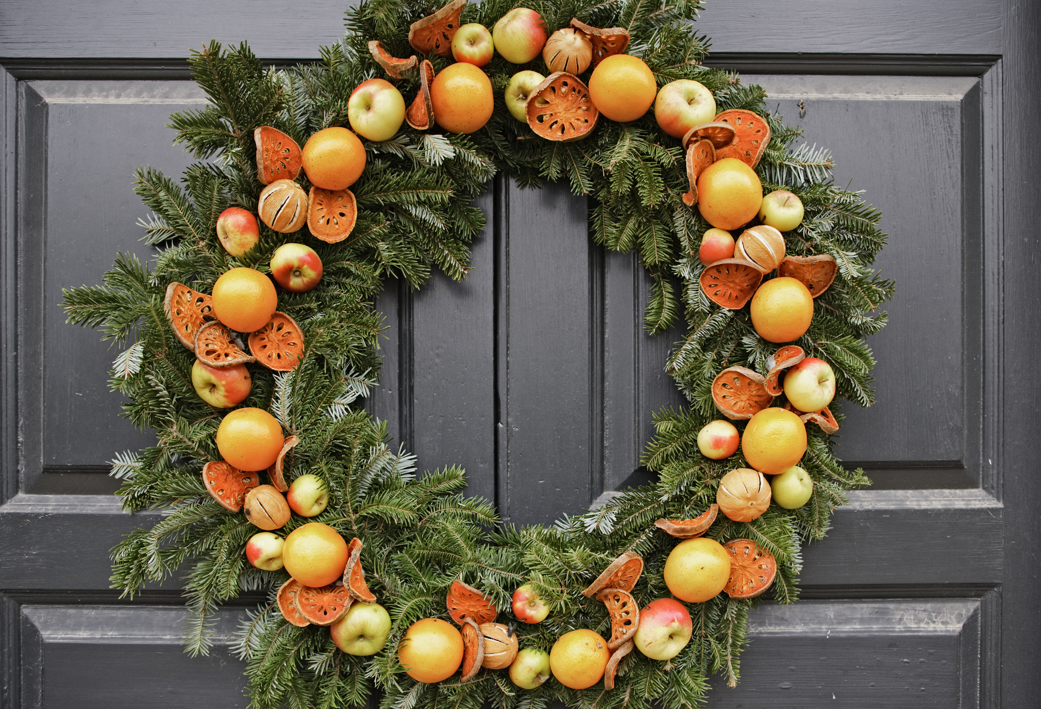 Gyümölcsből készült koszorú szürke ajtón