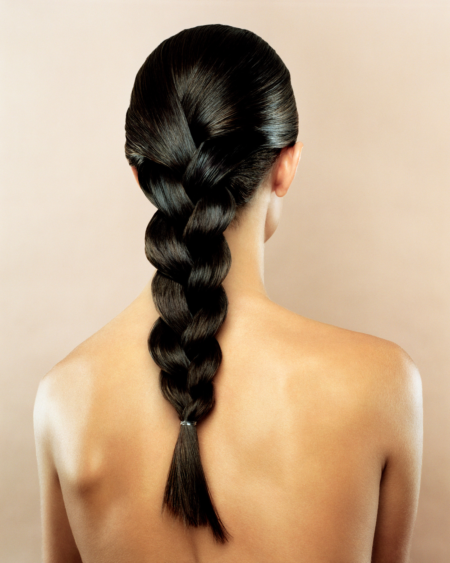 Egy nő hátulról, akinek csupasz a háta és be van fonva a haja