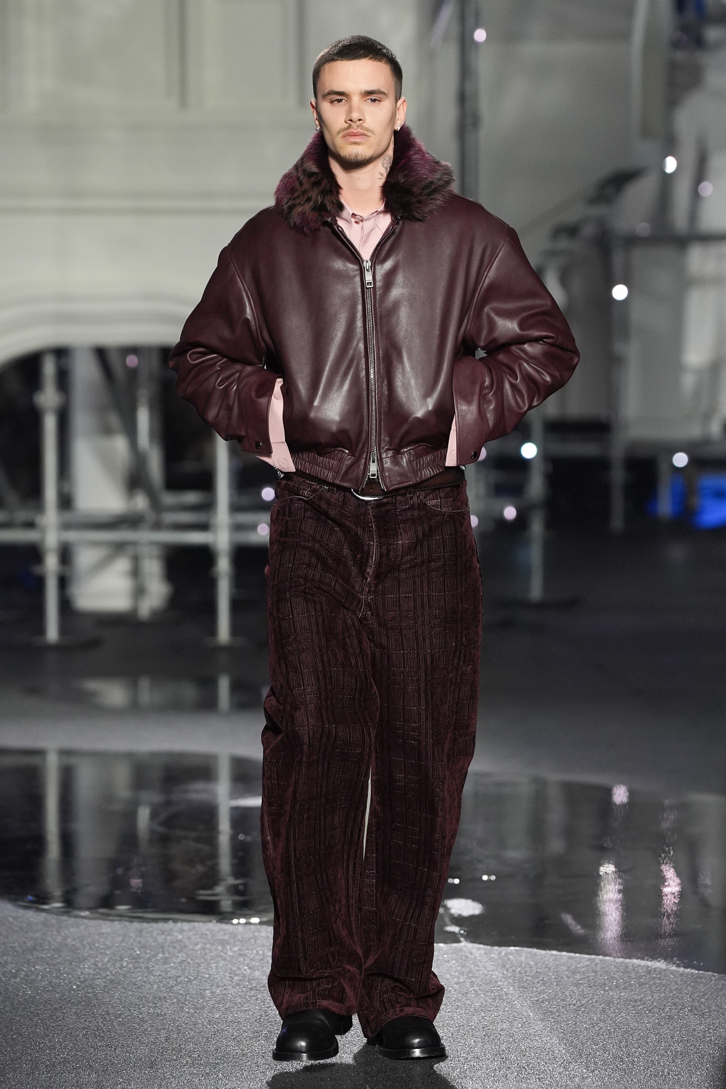Romeo Beckham teljes alakos képe, bordő bomberdzsekit visel a Burberry kifutóján a londoni divathéten