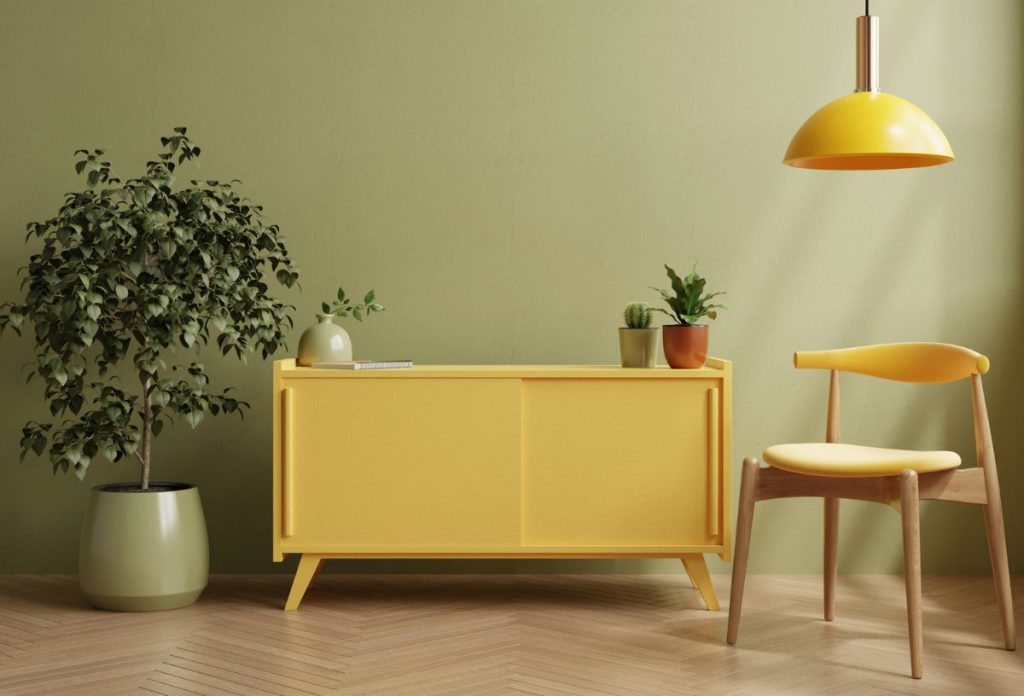 vajsarga-lakasdekoracio-2026 | Marie Claire Vajsárga árnyalatokkal berendezett szoba komóddal, lámpával, székkel, nagy szobanövénnyel