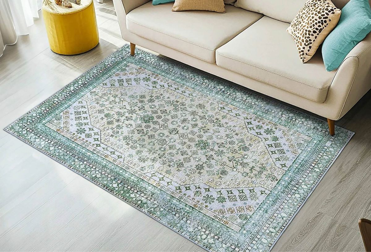 Zöld halvány minás szőnyeg nappaliban felülnézetből fehér kanapéval, oldalt sárga, henger alakú asztallal