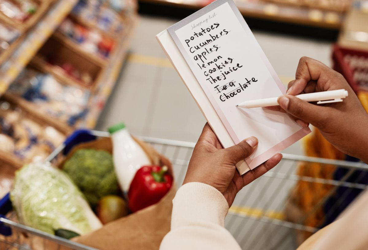 japan-modszer-sporolas-3-tipp | Marie Claire Nő bevásárlólistát néz boltban a bevásrlókocsi felett