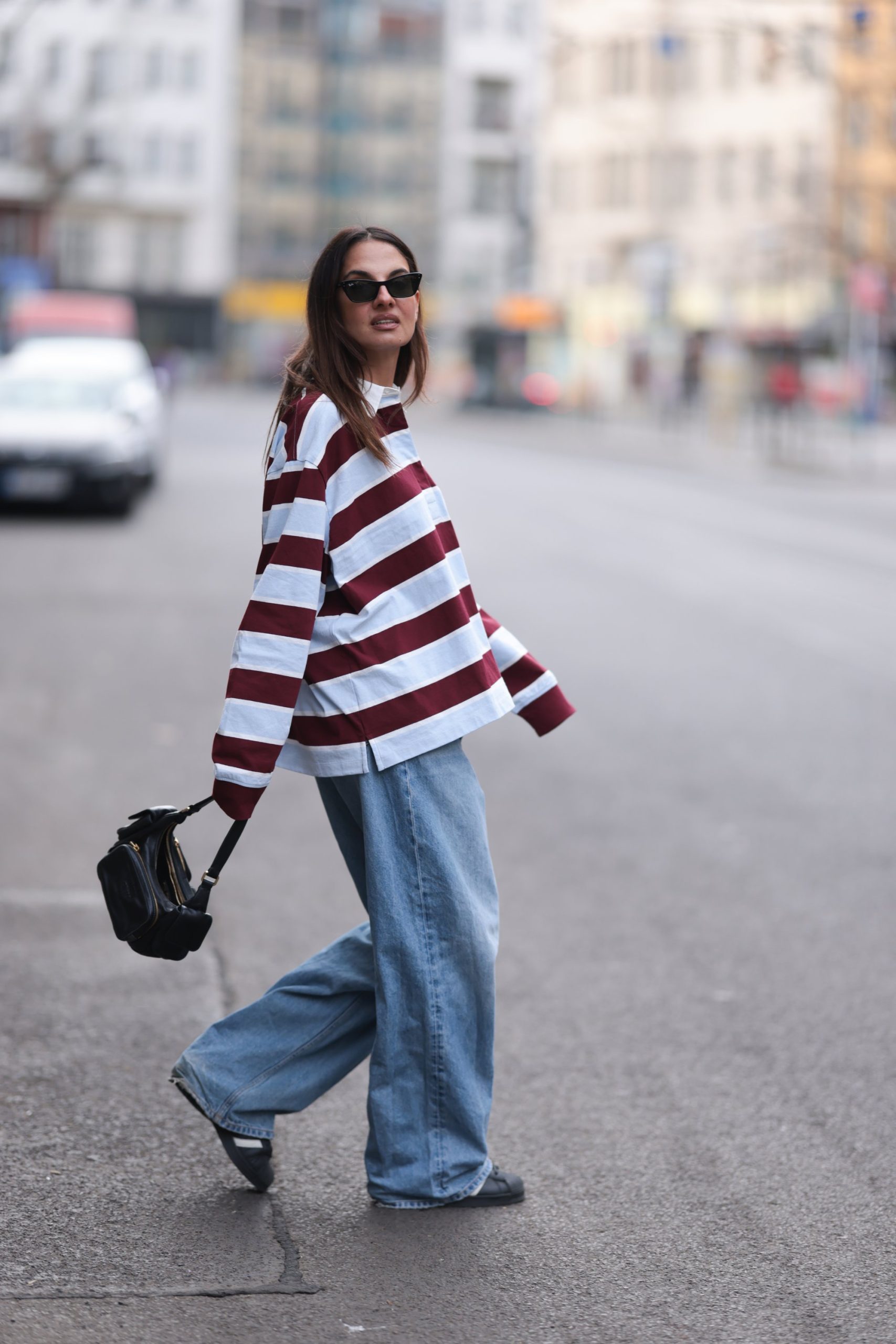 modell csíkos pólóban vonul az utcán