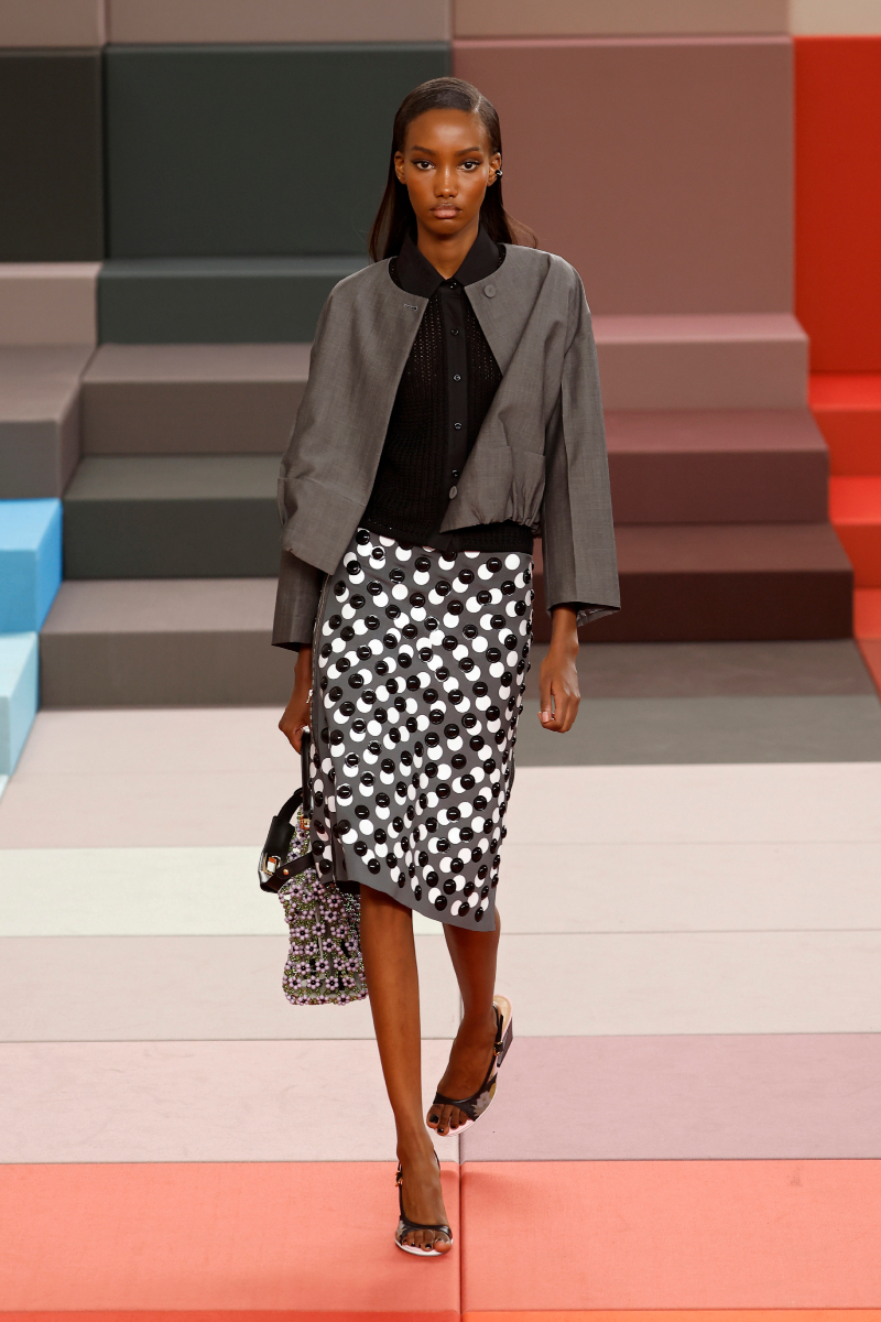 2026-tavasz-trend-library-chic-sikkes-konyvtaros | Marie Claire Színes bőrű modell a Fendi 2026. tavaszi–nyári bemutatóján szürke blézerben, fekete blúzban, mintás ceruzaszoknyában
