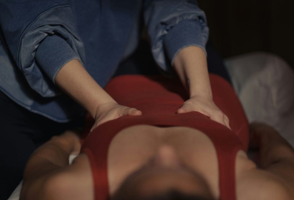 hasmasszazs-lapos-has | Marie Claire Női masszőr egy piros trikós nő hasát masszírozza