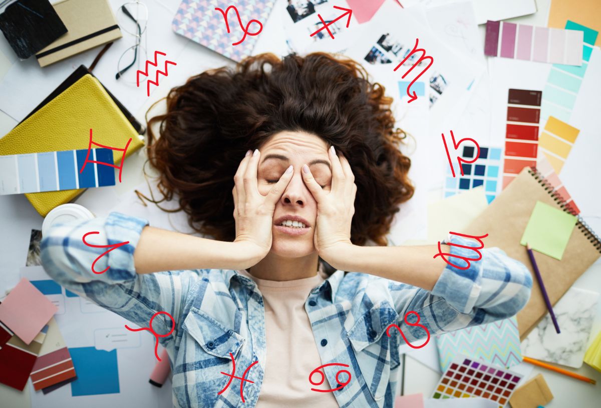 Egy barna hajú nő fogja a fejét, ki van borulva, a nagy rendetlenségben. Horoszkóp szimbólummal.