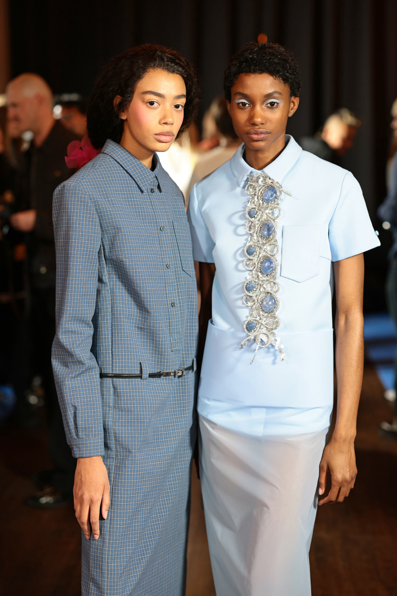 Két színes bőrű modell a Marc Jacobs 2026-os őszi–téli bemutató backstage-ében New Yorkban, mindketten kékes tónusú ruhákban