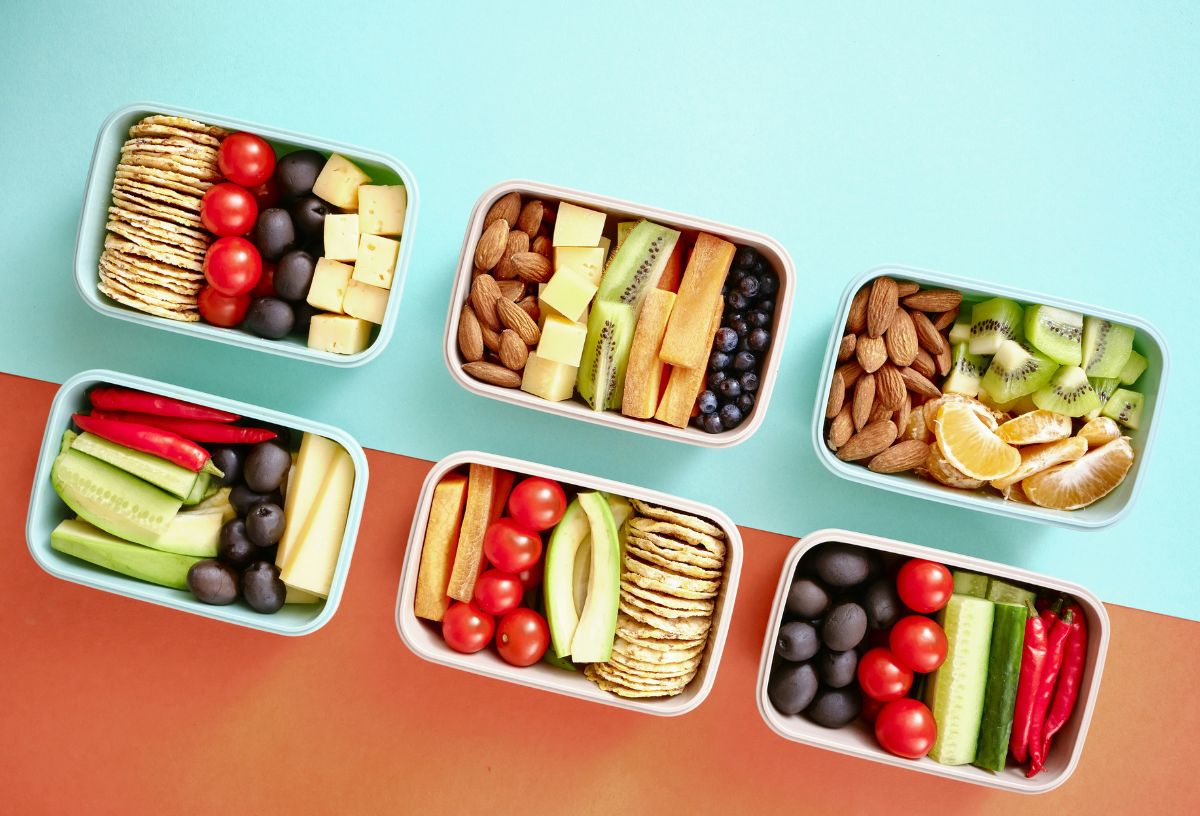 Zöld-narancs osztott háttéren egészséges ételek hat dobozban