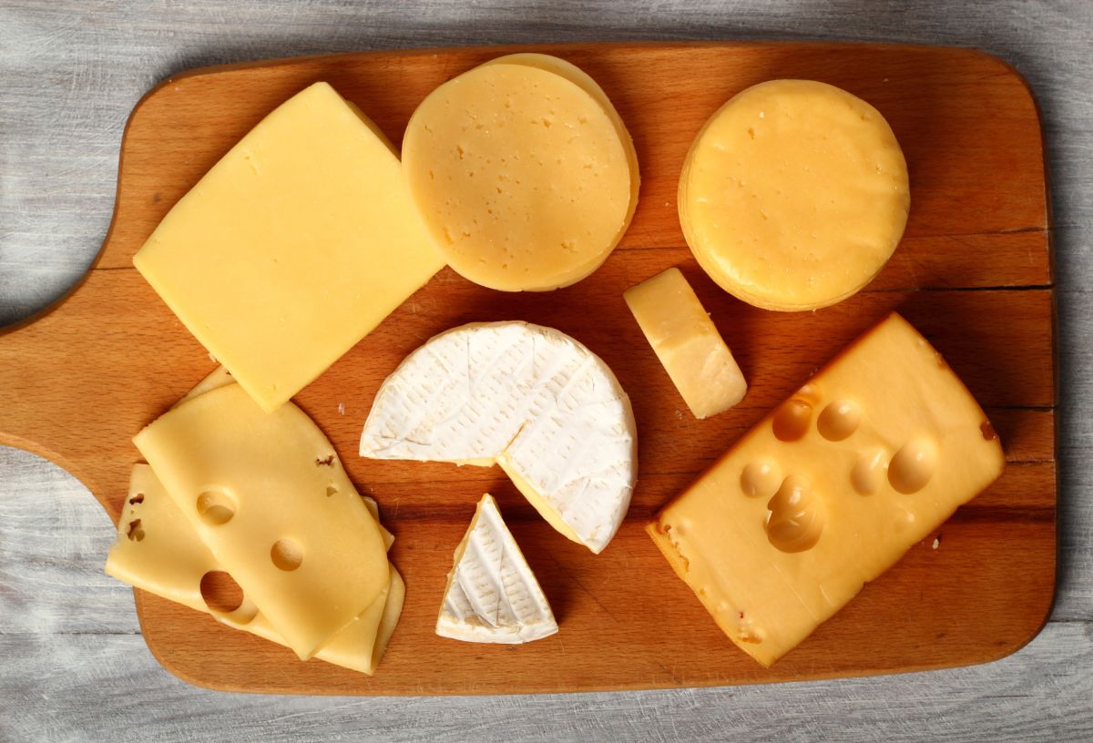 Különböző típusú sajtok fa deszkán felülnézetből