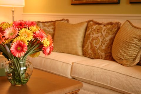 Egy régimódi kanapé, előtte vázában egy csokor virág