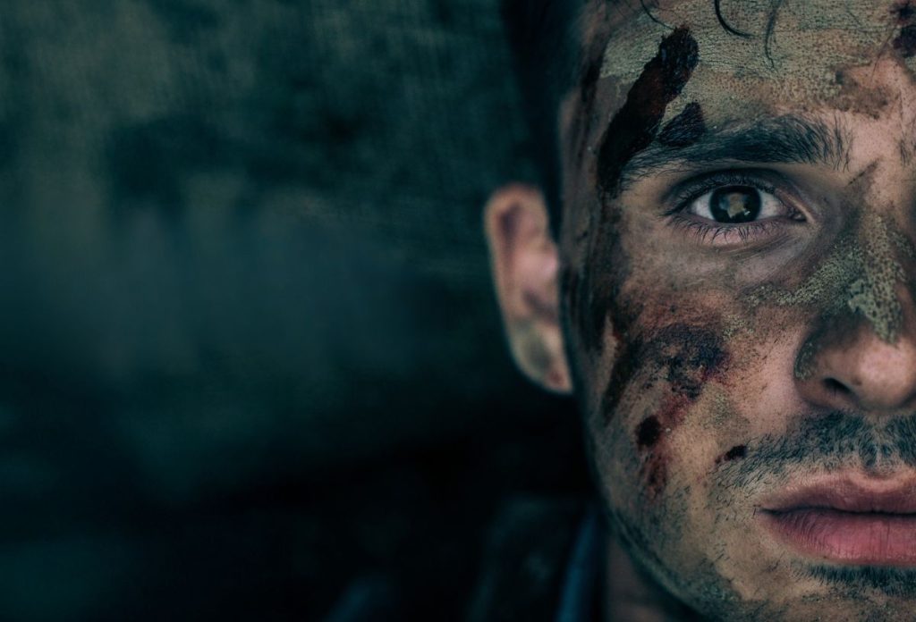 Laudon Andrea Távol című filmjének plakátja, sötét háttér előtt jobb szélen egy maszatos arcú férfi fél arca