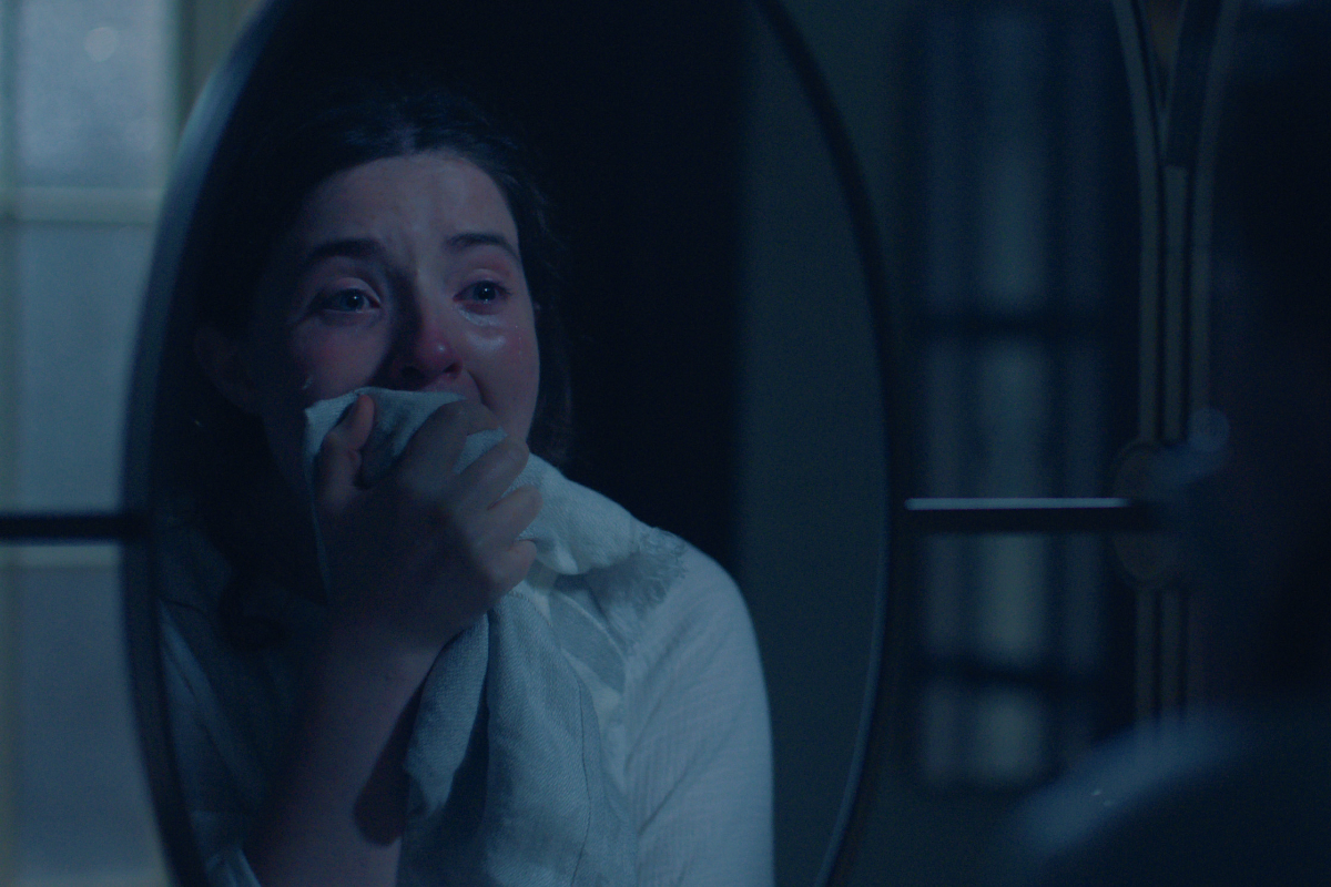 Daisy azaz Lucy Halliday a Testamentumok sorozatban tükör előtt kiabál, a szája elé teszi a kezét