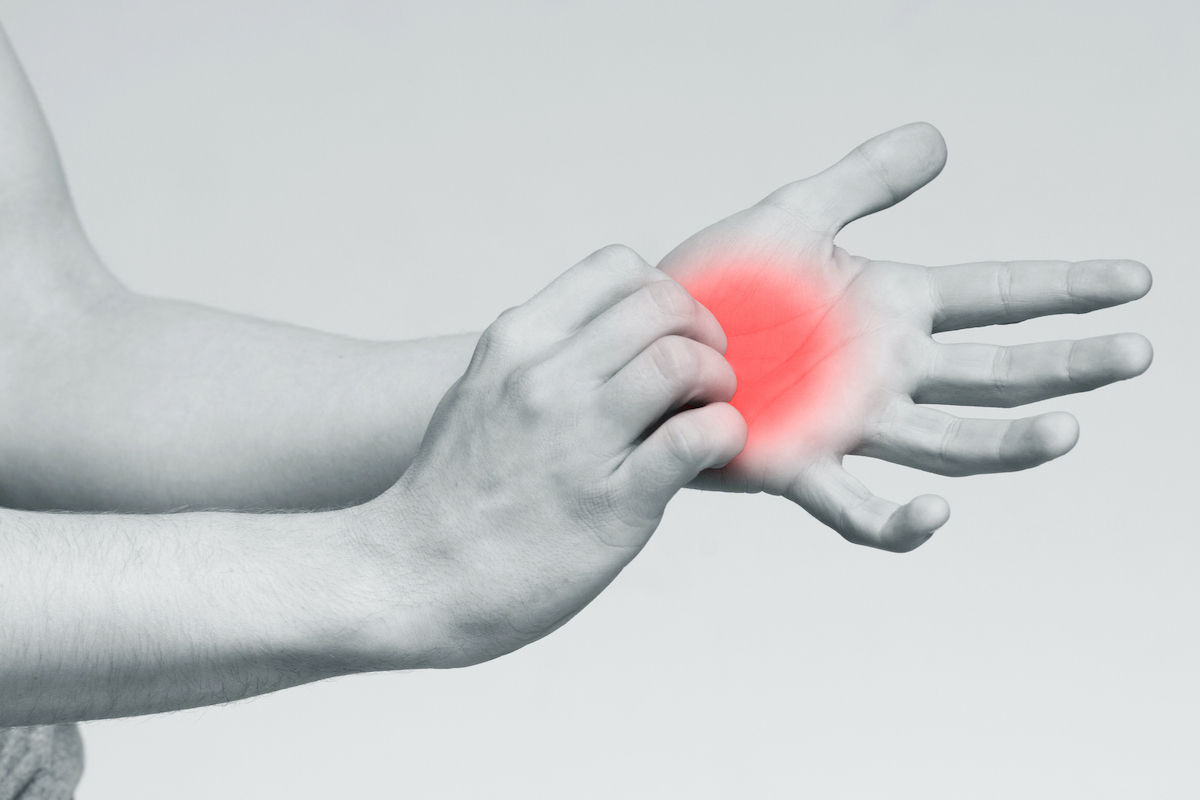 fekete-fehér képen jobb kéz bal, vörösre színezett tenyeret vakar