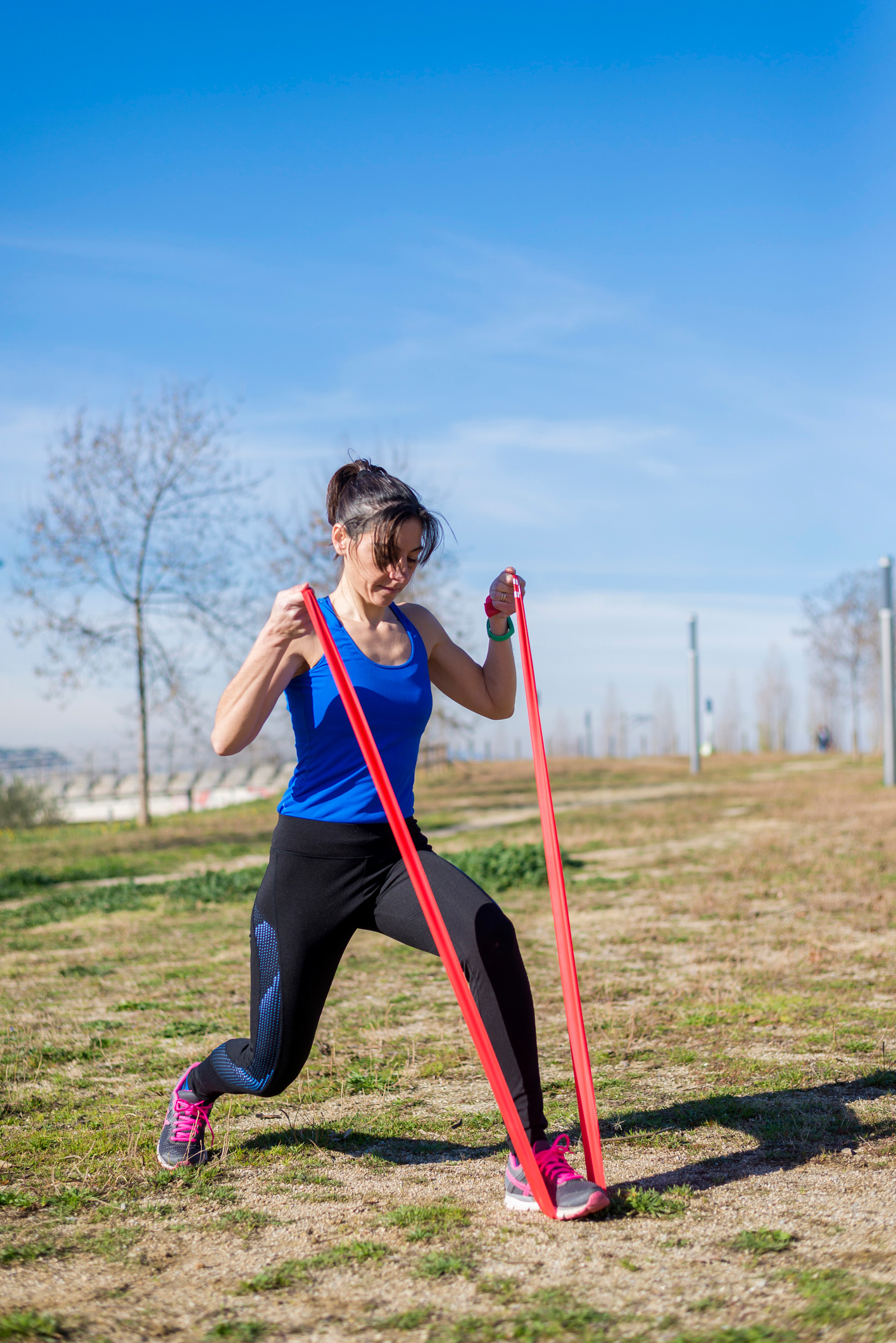 Női sportoló edz ellenállásos-szalaggal füves területen