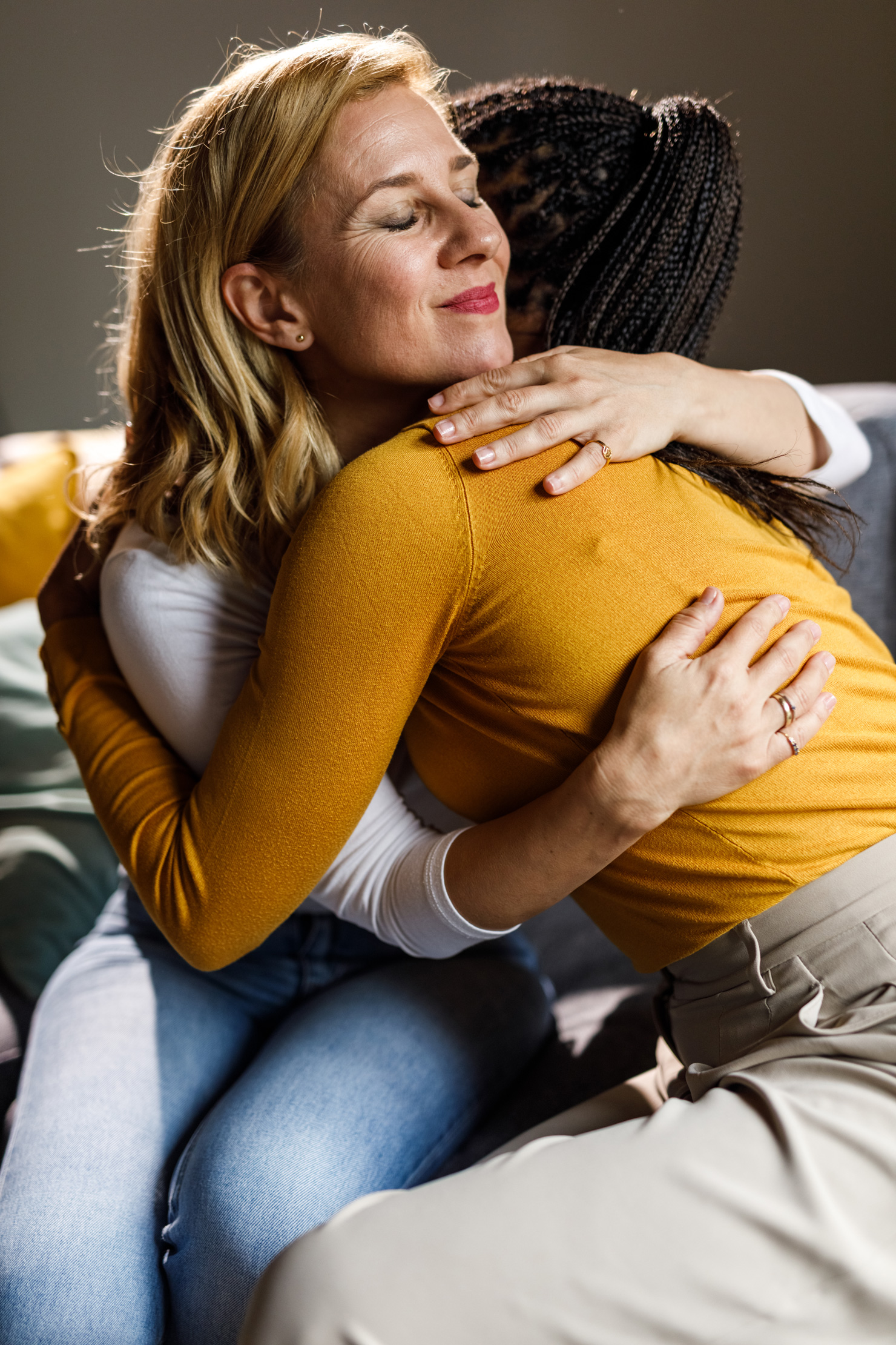 hogyan-vigasztaljunk-mondatok | Marie Claire Két középkorú felnőtt nő, akik a kanapén ülnek és átölelik egymást