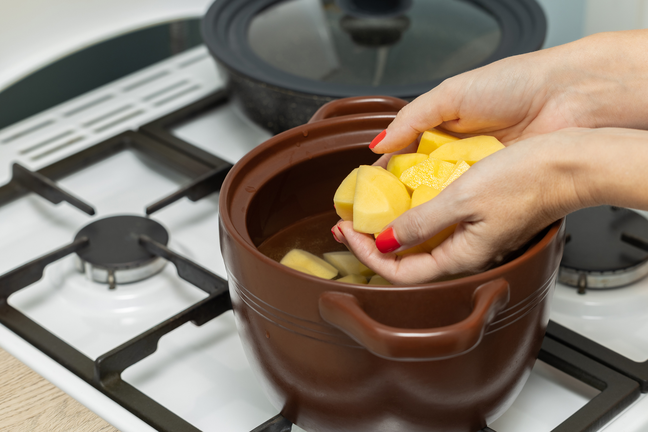 Nő főtt krumplit tesz egy tálba