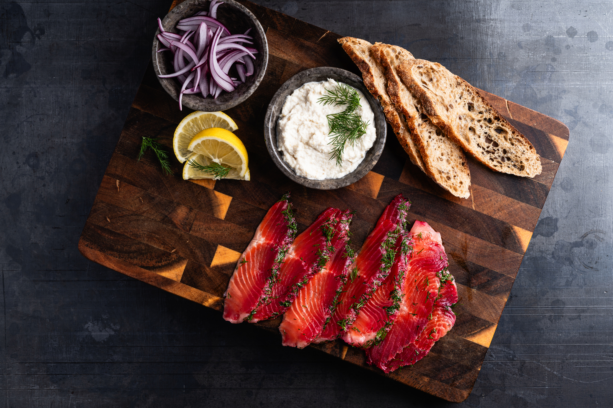 lazac, tormakrém, hagyma, rozskenyér deszkán, felülnézetből