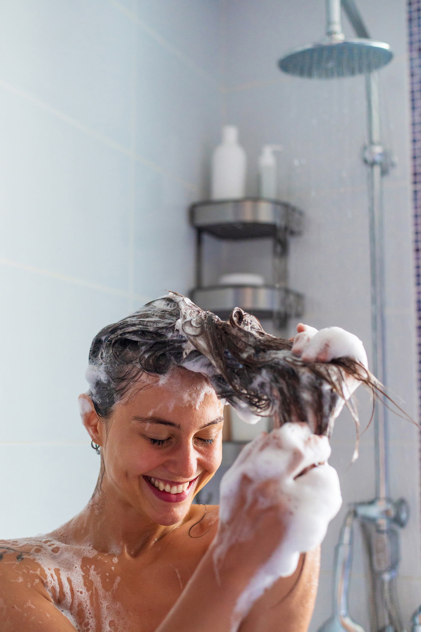 tunetek-csokkentese-allergia-szezon | Marie Claire Fiatal mosolyogva zuhanyozik a fürdőszobában a napsütéses reggelen.