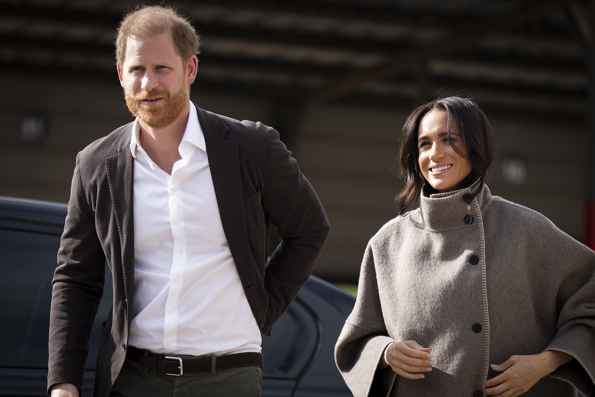 Meghan Markle barna kabátban és Harry herceg fehér ingben és zakóban 2026-ban Jordániában.