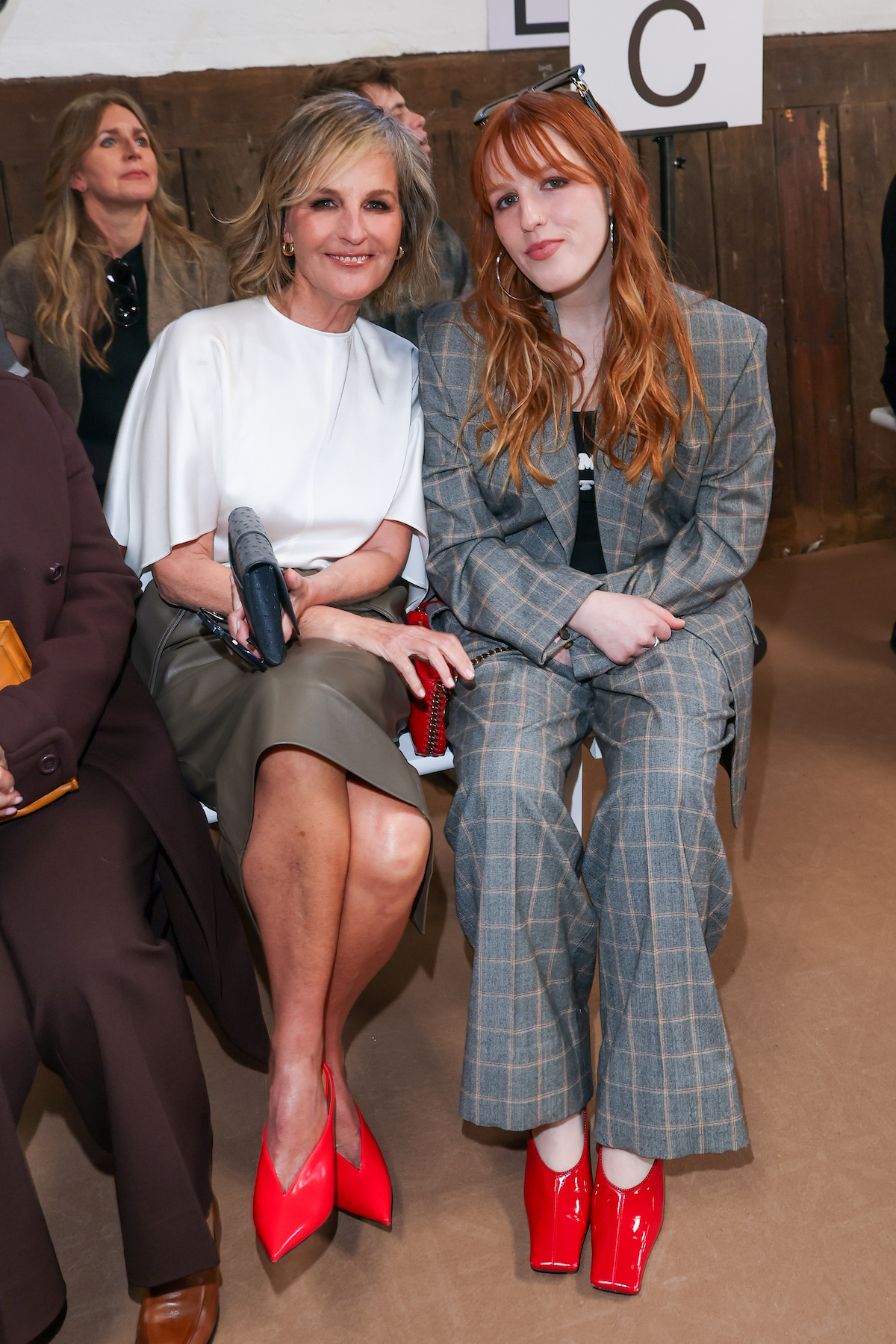 Helen Hunt és Makena Lei Carnahan piros cipőben, ülve a Stella McCartney 2026-2027 őszi-téli bemutatóján a 2026-os párizsi divathéten