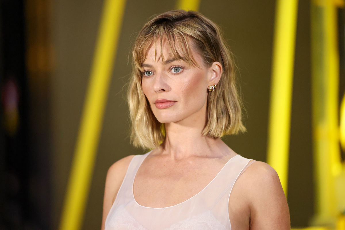 Margot Robbie rövid, szőke hajjal sárga háttér előtt