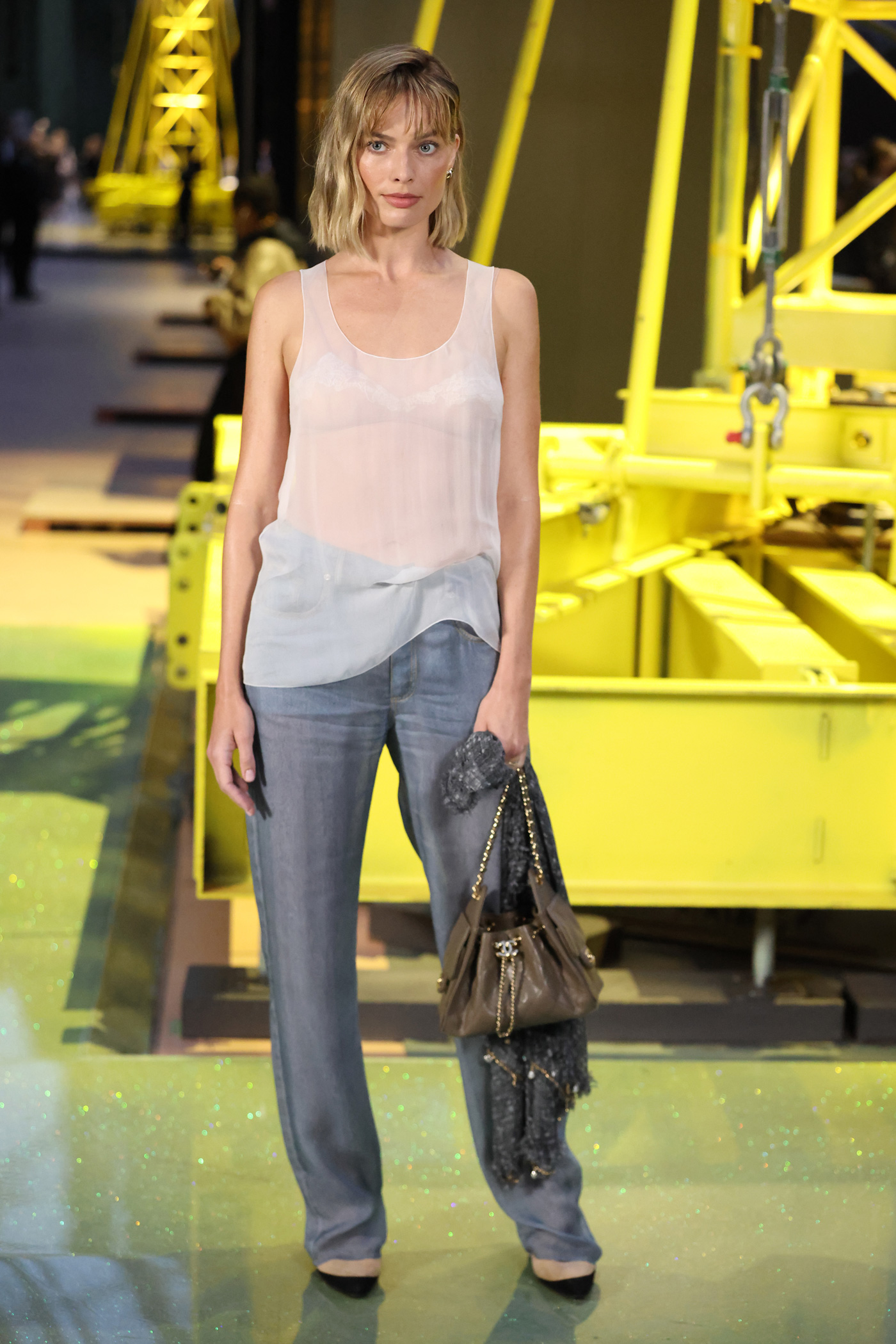 Margot Robbie bob hajjal, áttetsző felsőben és farmerben a 2026-os párizsi divathéten