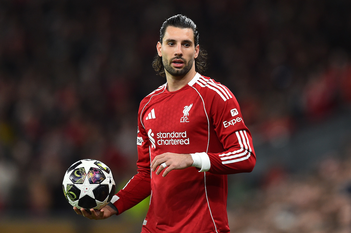 Szoboszlai Dominik piros mezben a pályán, labdával a kezében