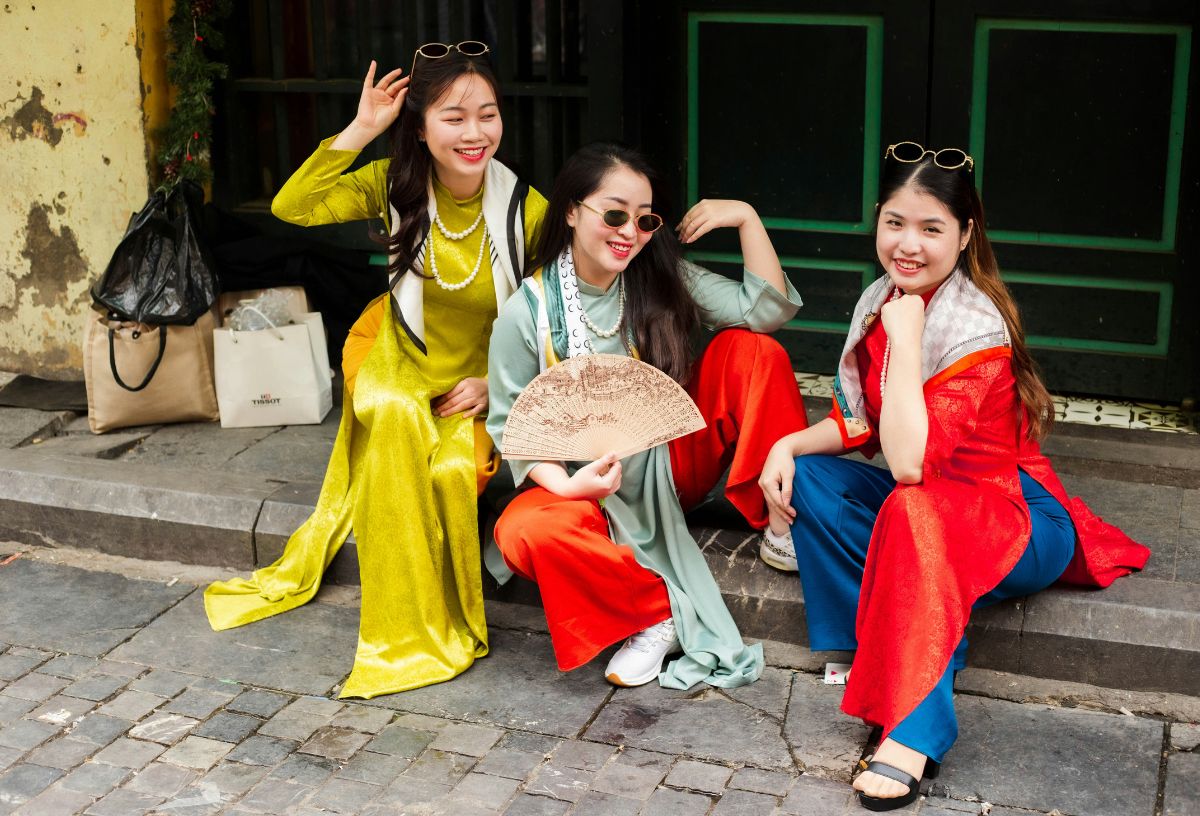 Thai ruhában ázsiai nők ülnek a járda szélén