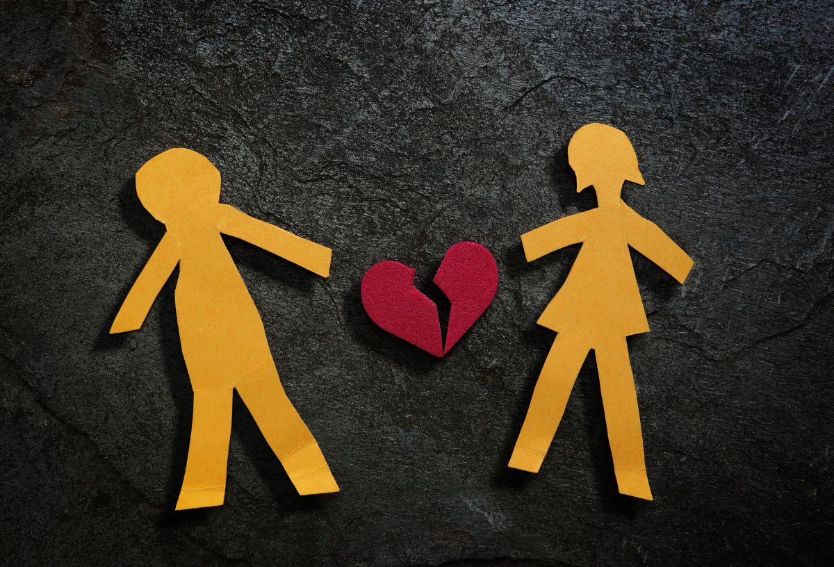 Sárga papírból kivágott férfi és női alak között elszakított piros szív