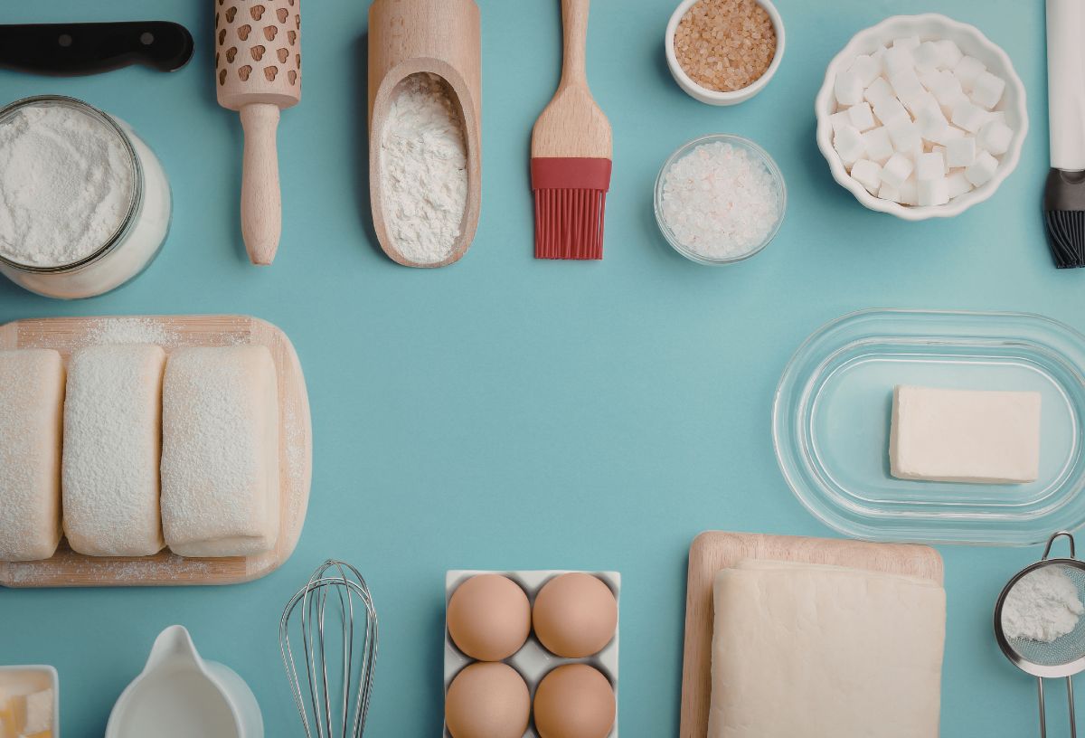Kék háttéren sütéshez használt eszközök és alapanyagok, köztük szukralóz