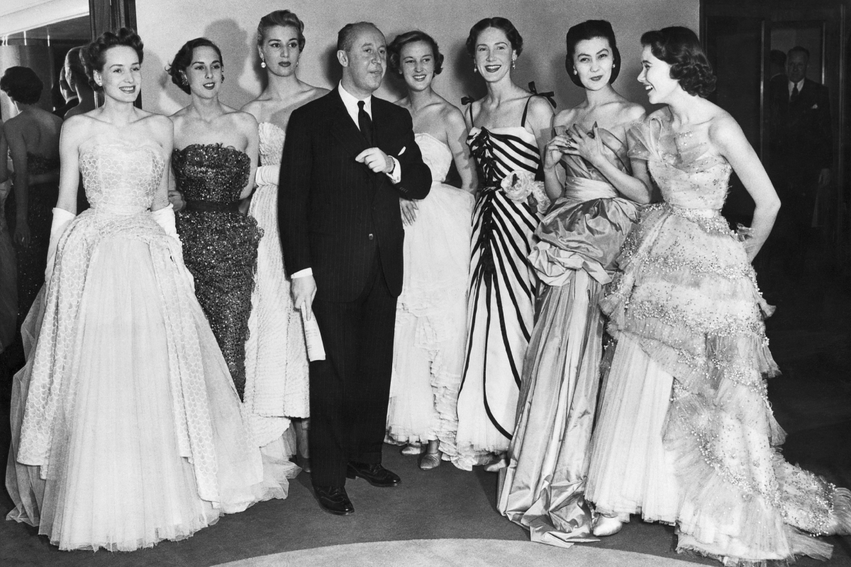 Christian Dior francia divattervező saját tervezésű estélyi ruháit viselő modellekkel áll egy divatbemutatón. 1950