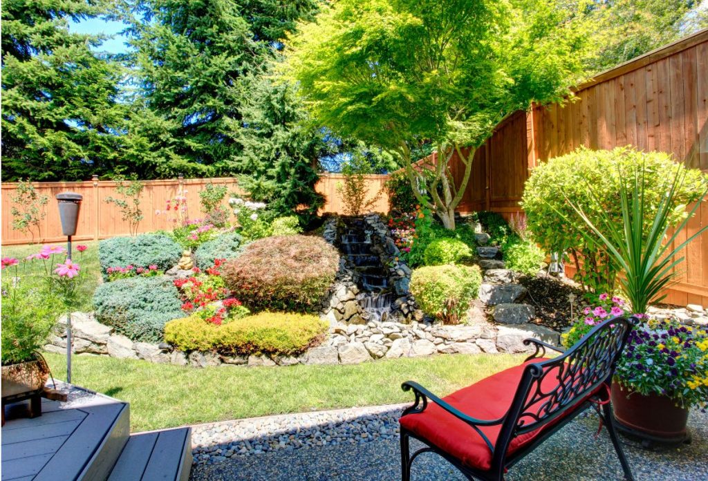 kis-kert-kerttervezes-otlet | Marie Claire Apró belső kert zöld és virágos növényekkel, kerti karosszékkel