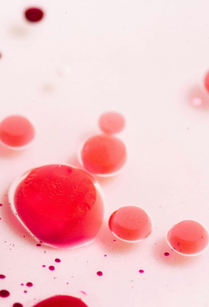 Piros menstruációs vérszerű pettyek rózsaszín felületen