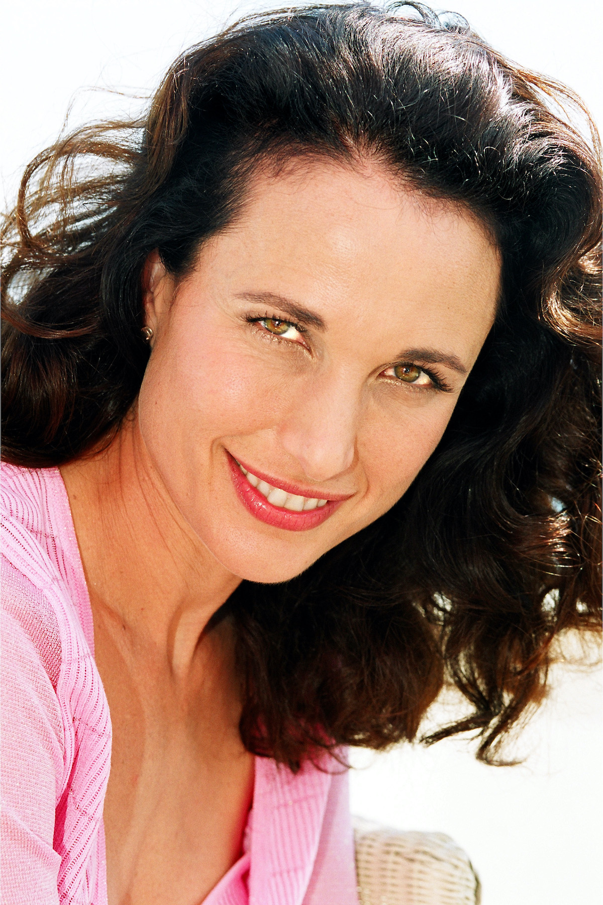 Andie MacDowell portré: rózsaszín felsőben, fehér háttér előrr