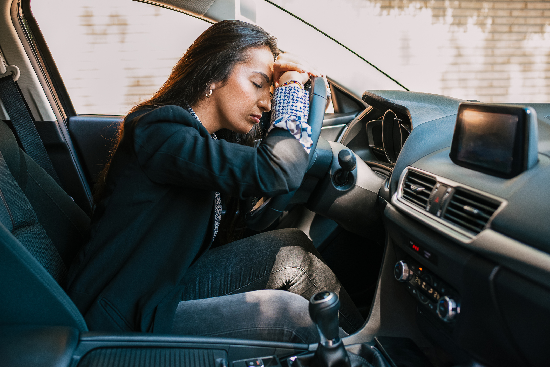 nő fáradtan ül az autóban