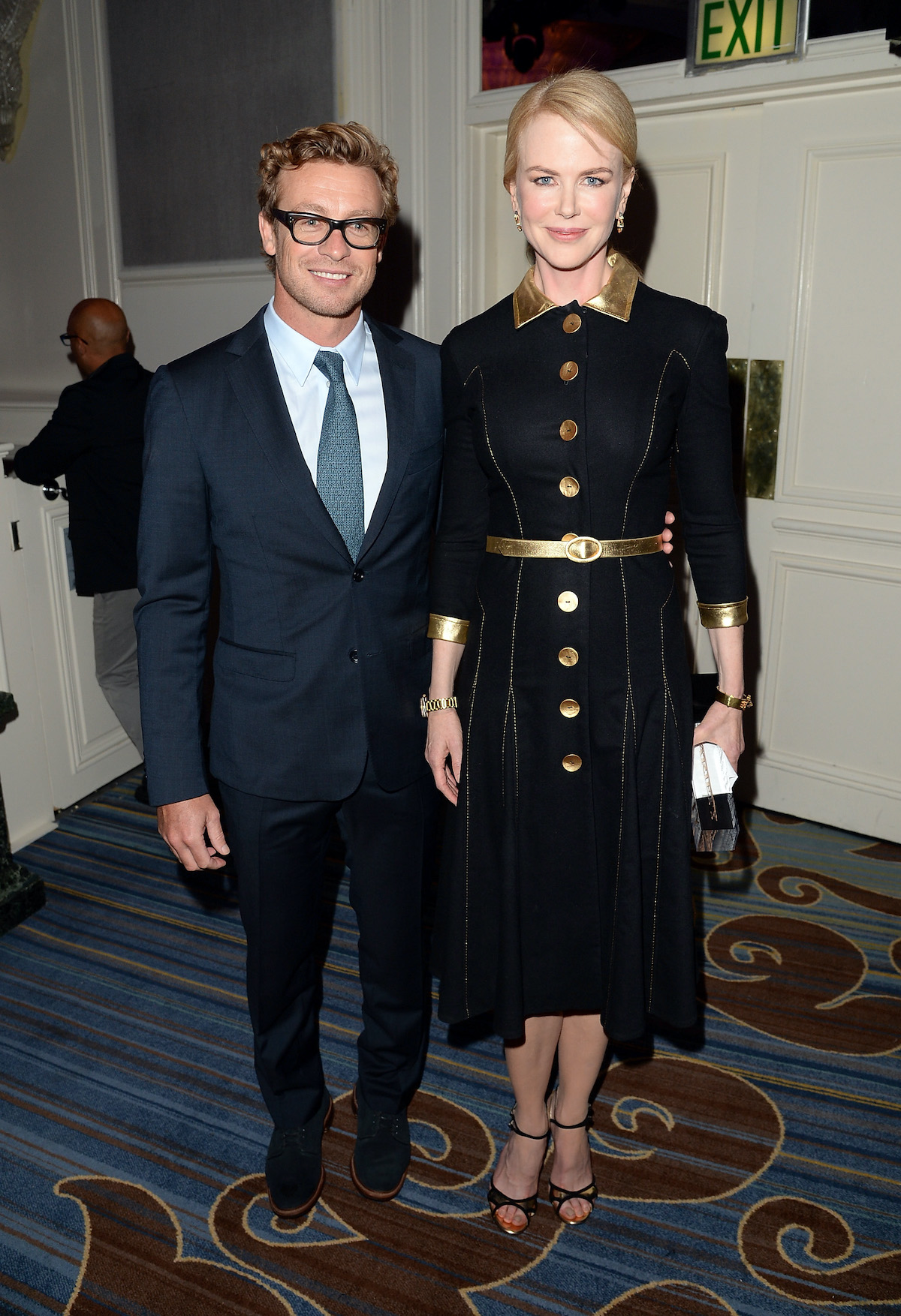 Nicole Kidman fekete kosztümben és mellette Simon Baker szemüvegben