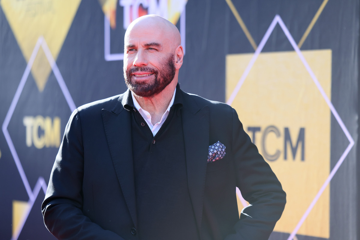 John Travolta fekete mellényben és zakóban, szakállal, a háttérben TCM felirat