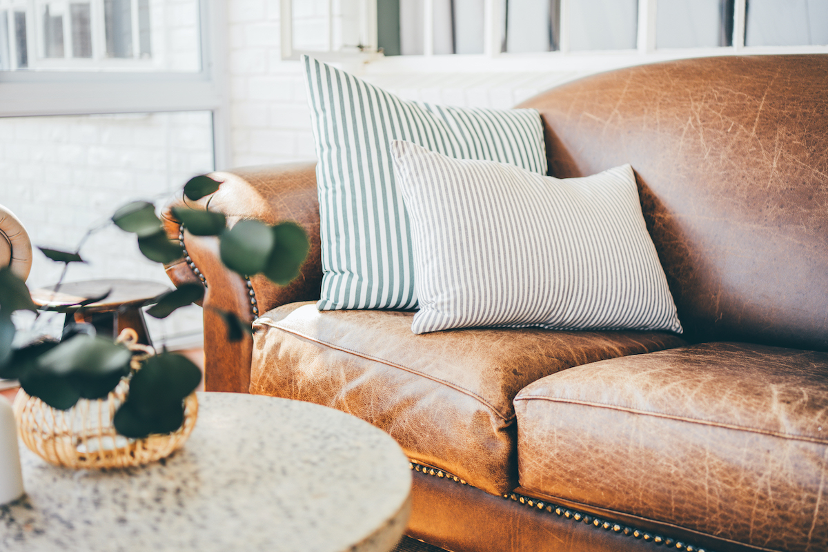 Nappali belső, dohányzóasztal, függönyök, bőrkanapé.