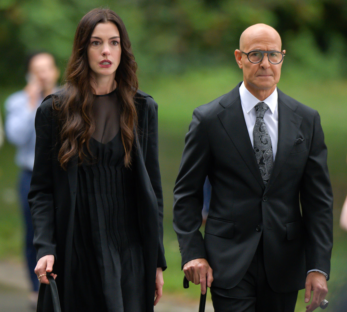Anne Hathaway és Stanley Tucci feketében, zöld háttér előtt