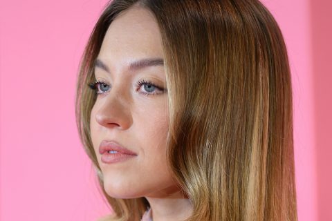 Sydney Sweeney arcközeli rózsaszín háttérrel