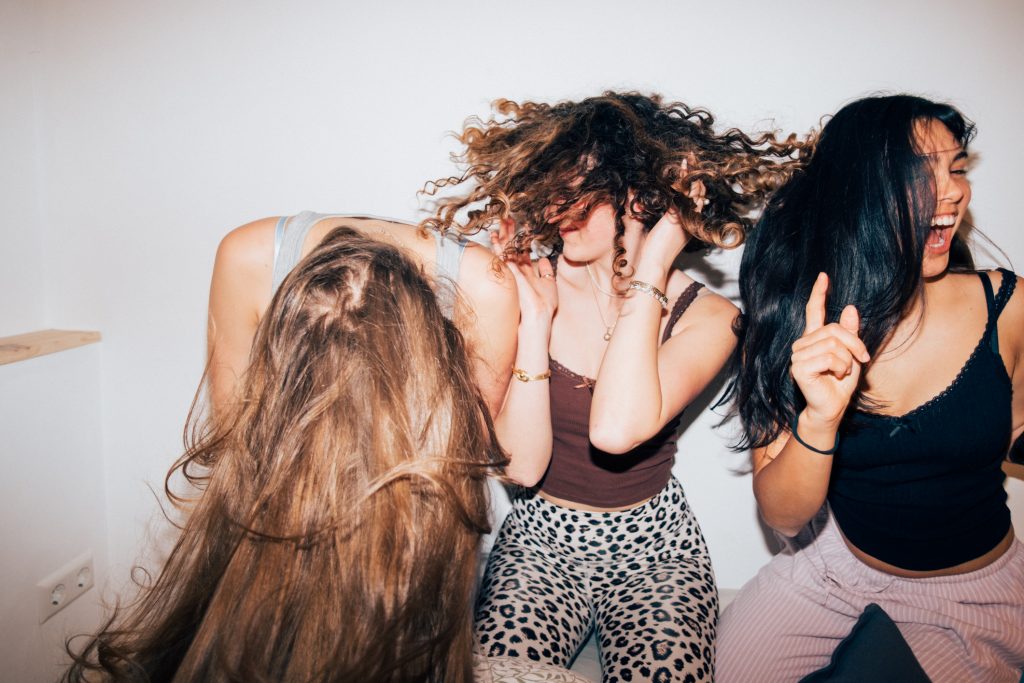 Három fiatal lány táncol buliban