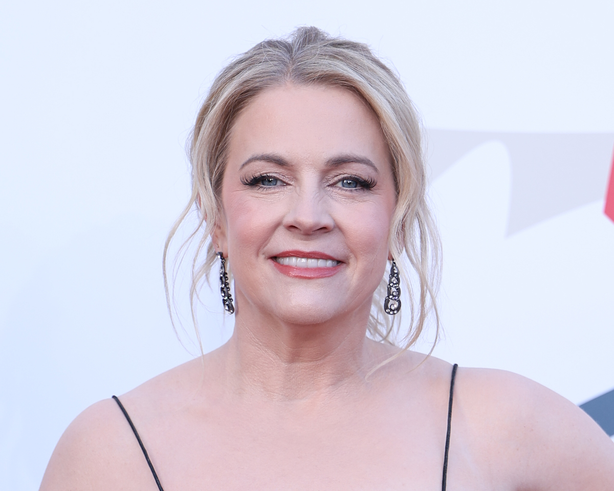Melissa Joan Hart nagy fülbevalóval, feltűzött hajjal mosolyog