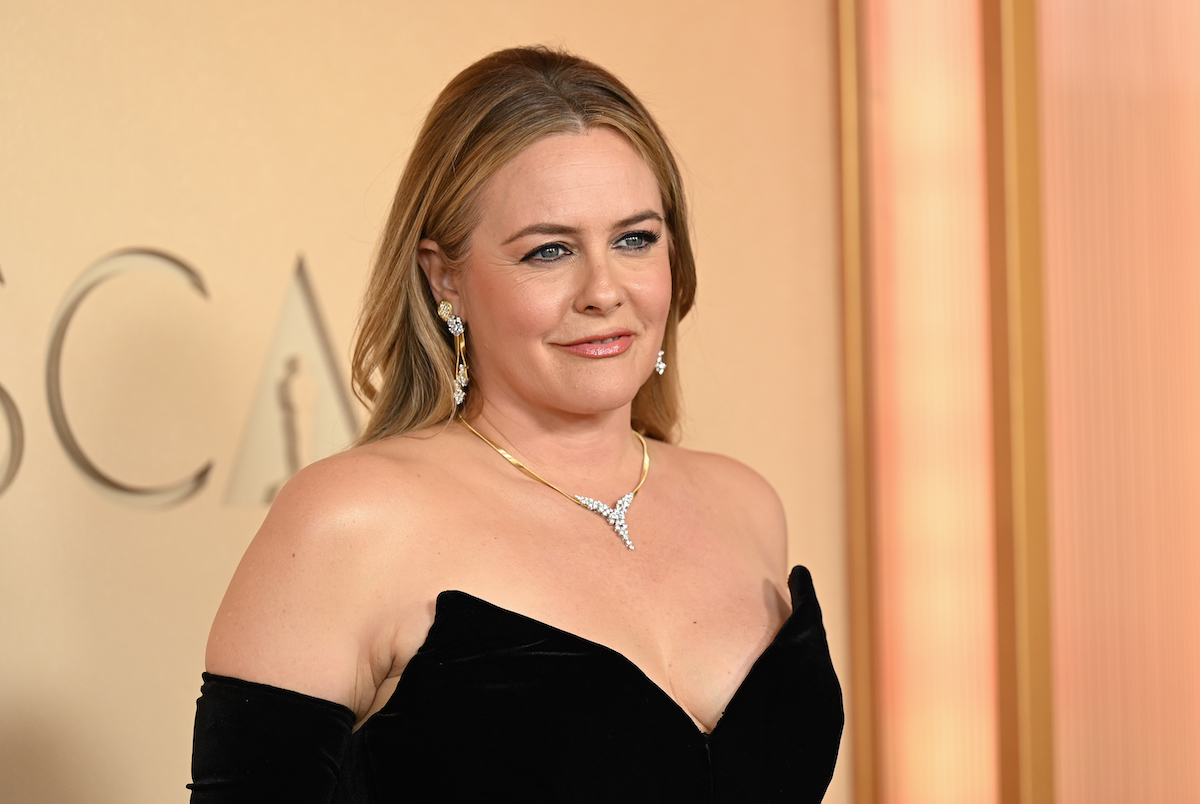 Alicia Silverstone feket pánt nélküli ruhában és ékszerekben