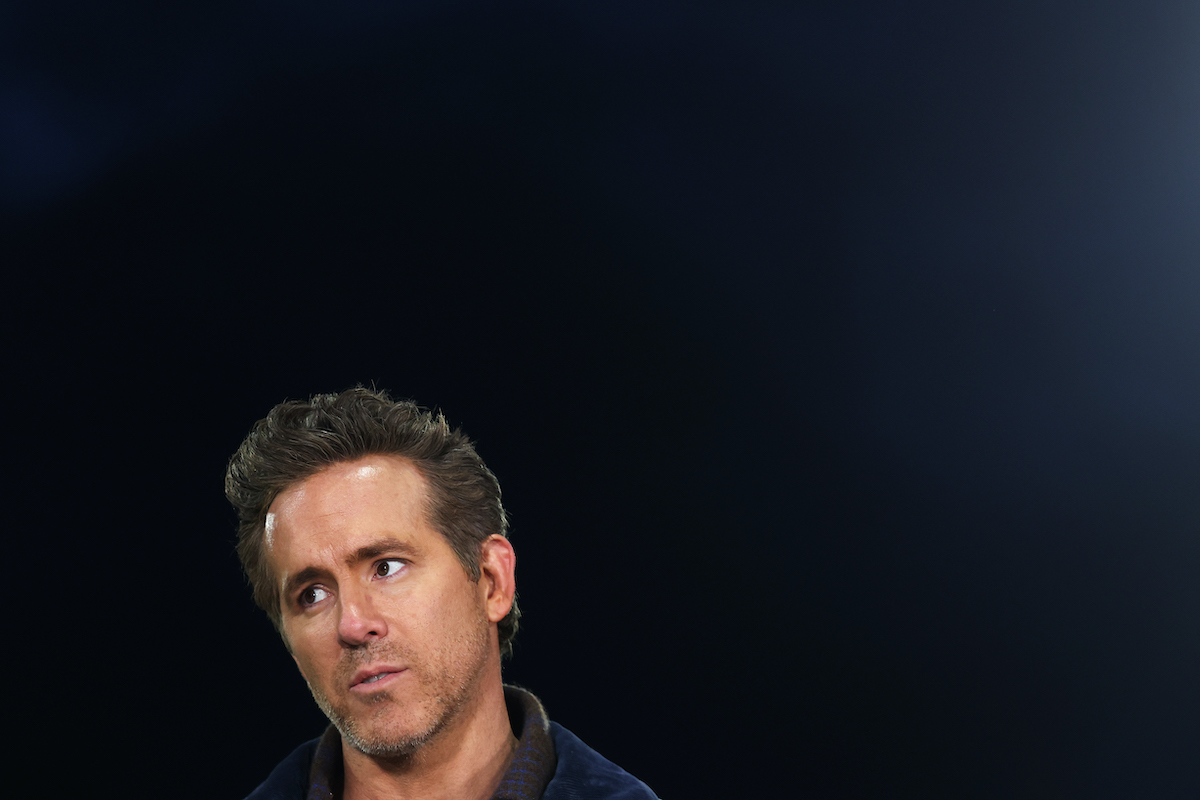 Ryan Reynolds sötét háttér előtt oldalra néz