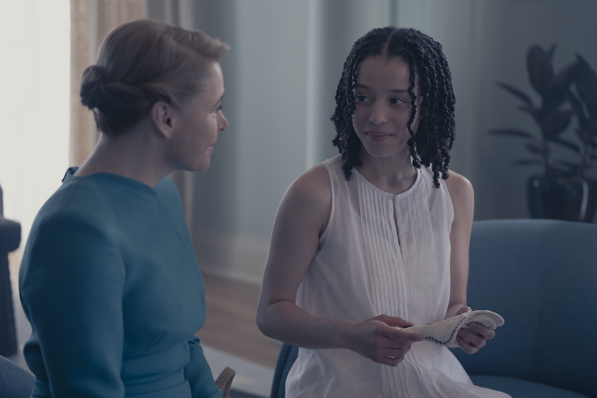 kék ruhás nő és mellette egy fehér ruhás nő, beszélgetnek