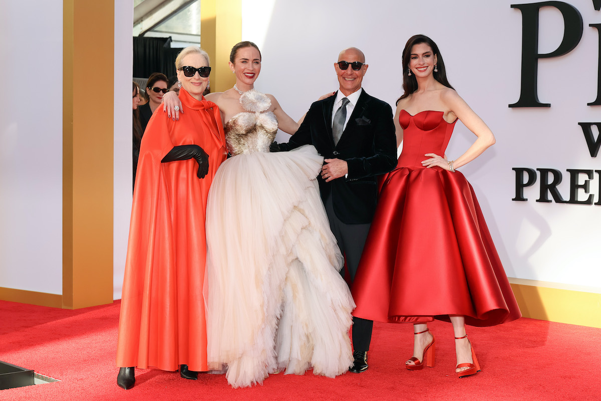Meryl Streep piros köpenyben, napszemüvegben, Emily Blunt fehér estélyiben, Stanley Tucci öltönyben és Anne Hathaway szintén egy piros ruhában Az ördög Pradát visel 2. New York-i premierjén, a vörös szőnyegen.