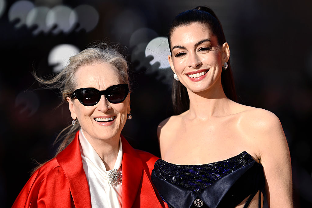 Meryl Streep napszemüvegben, piros blézerben és fehér ingben és Anne Hathaway fekete estélyiben