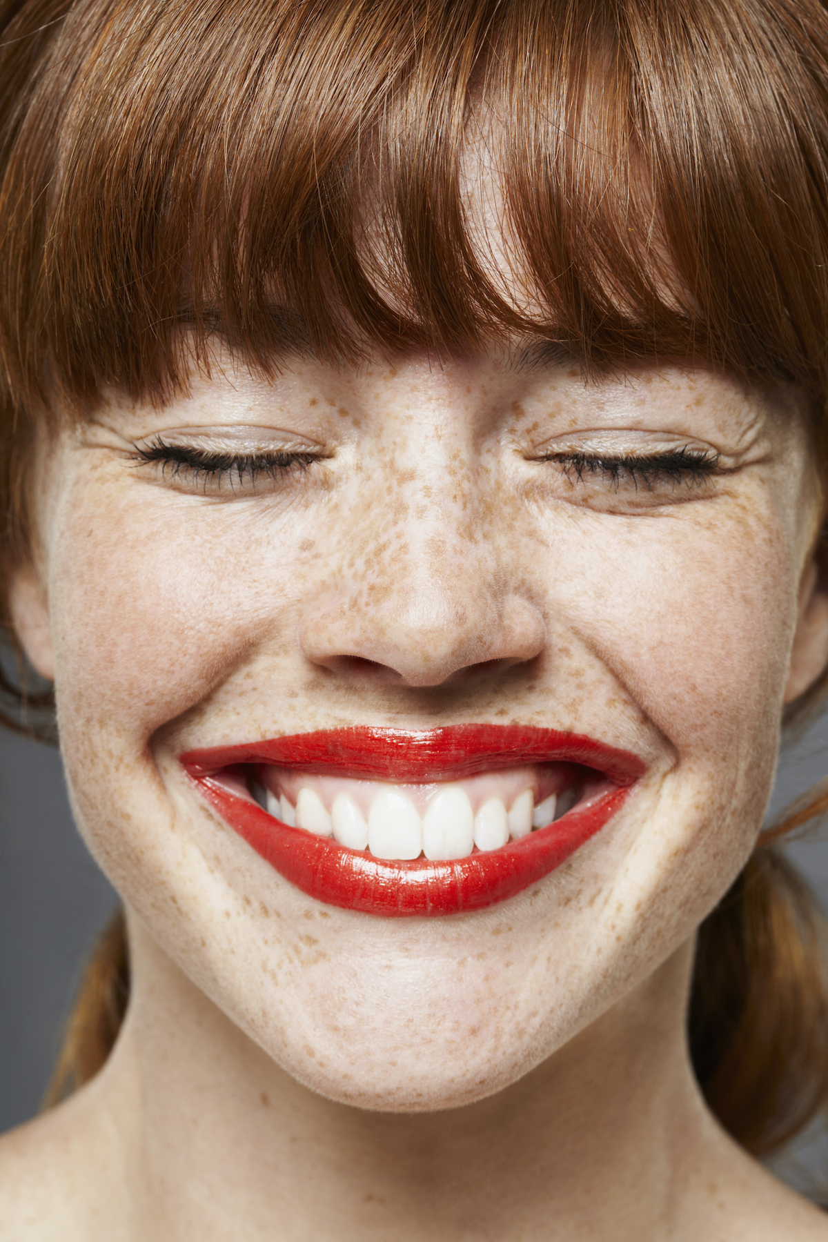 frufrus, szeplős nő behunyt szemmel nevet, piros rúzs