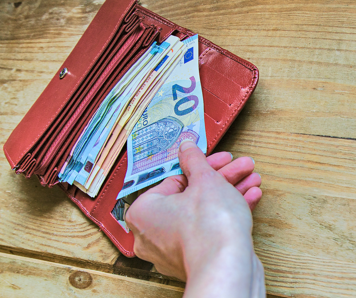 piros pénztárcából egy kéz 20 euróst vesz ki